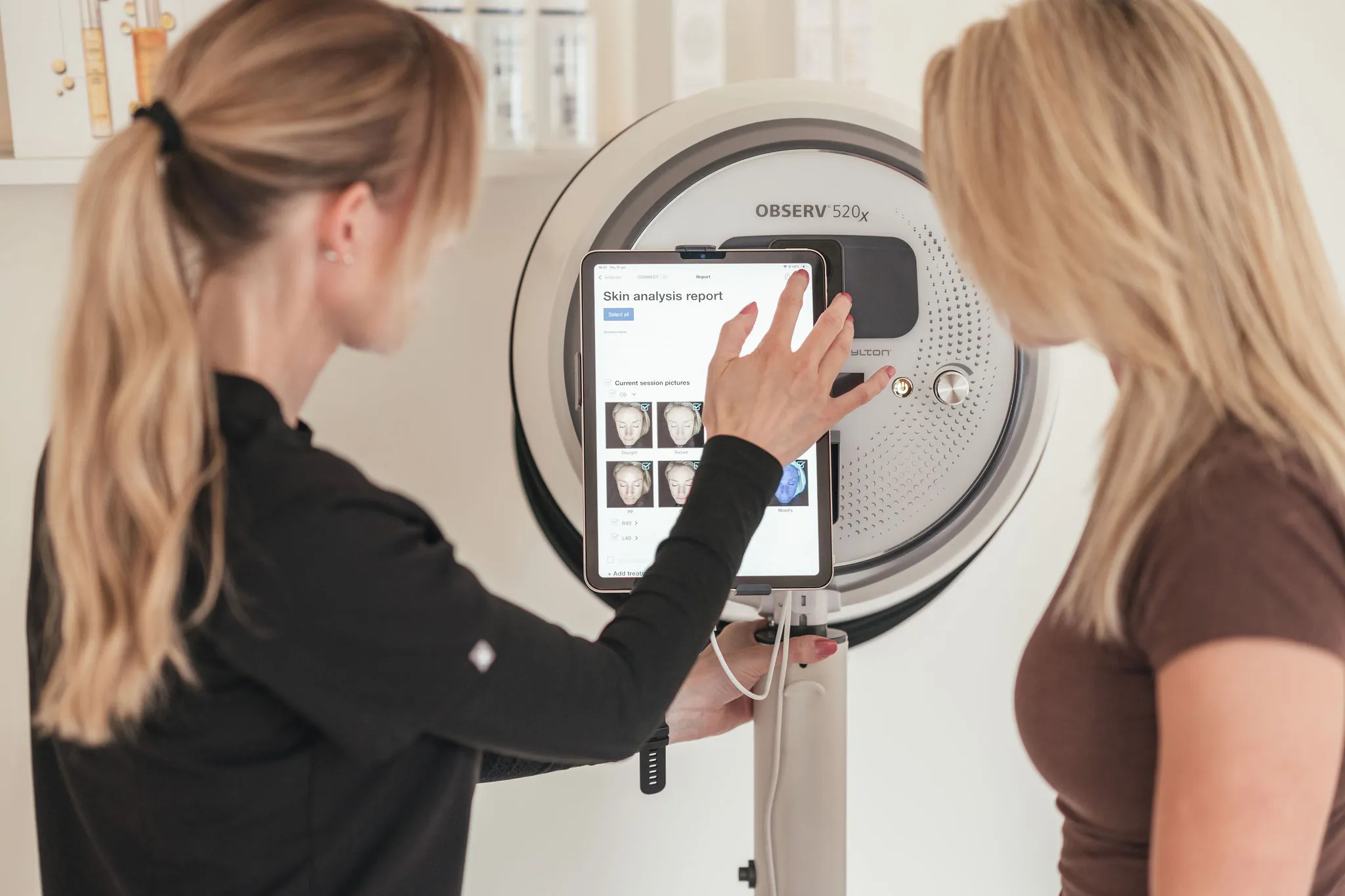 Practitioner using a skin analysis machine with a patient