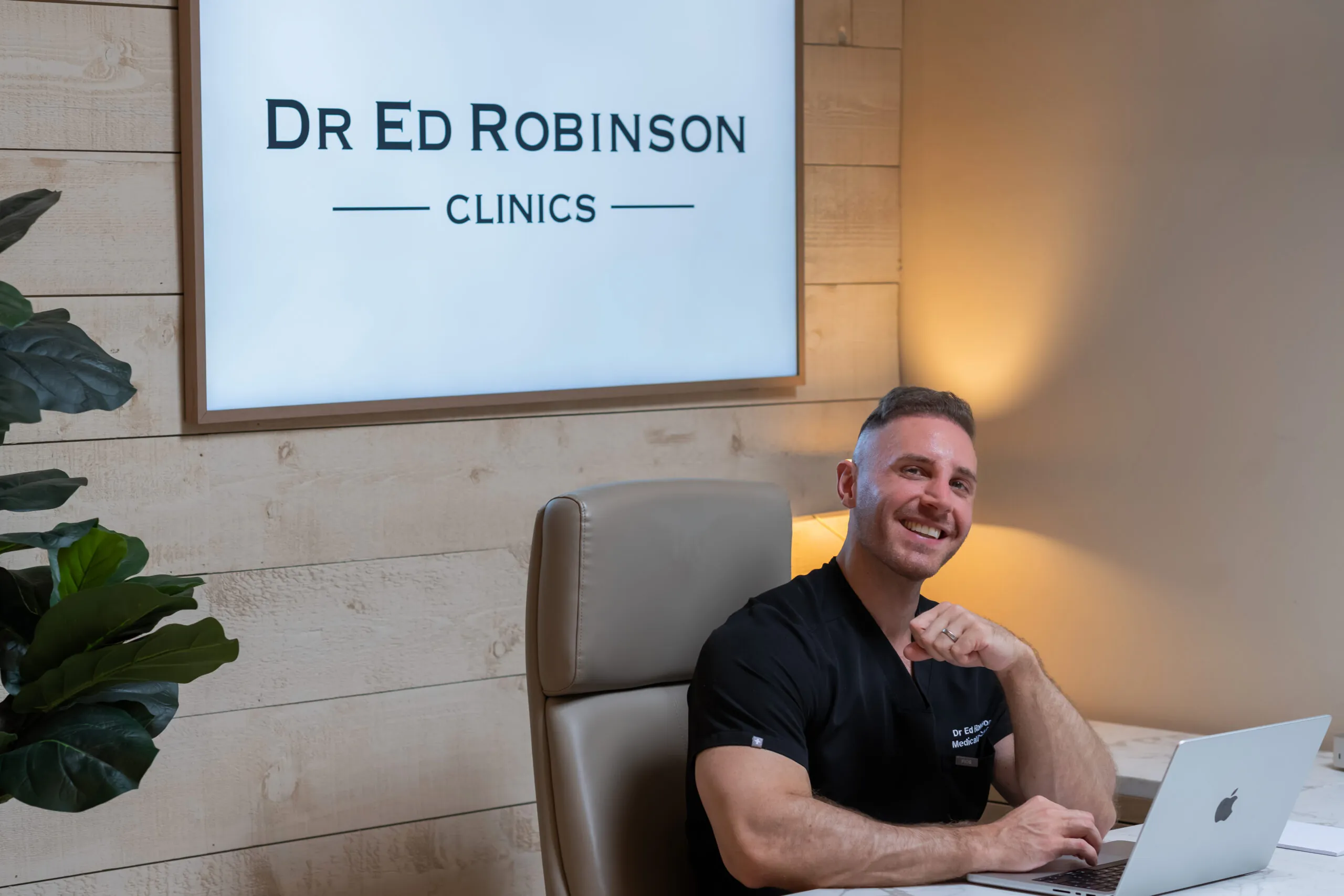 Dr Ed Robinson at his desk at his clinic in Hale, near Altrincham