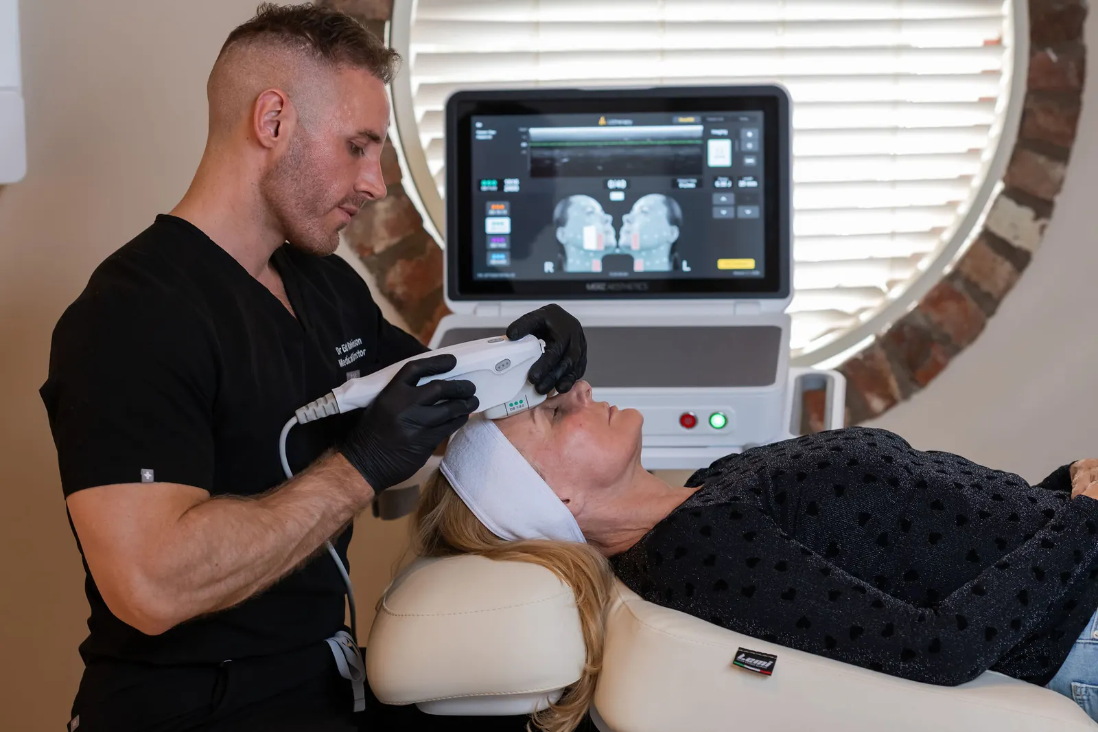 Dr Ed Robinson performing a skin tightening treatment on a patient